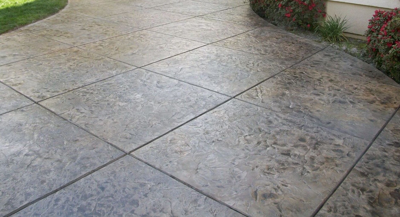 Stamped concrete walkway with decorative pattern leading to residential home entrance